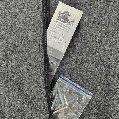 Grauer Filzstoff mit Reißverschluss, ein Beutel mit Schrauben und Innensechskantschlüssel sowie ein Etikett mit schwarzer Schrift und einer Zeichnung oben. Das Etikett beschreibt „Shrew Whisper String“ mit technischen Angaben.