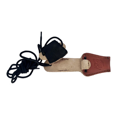 Zusammengerolltes schwarzes Band zu sehen, verbunden mit einem braunen Lederstück, das seitlich eine Prägung zeigt und mit beigem, rauem Leder an der Unterseite versehen ist. Das Band ist durch mehrere Lederteile geführt und geknotet.