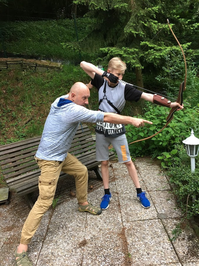 Sportbogen Schießtraining Junge mit Erwachsenem im Freien