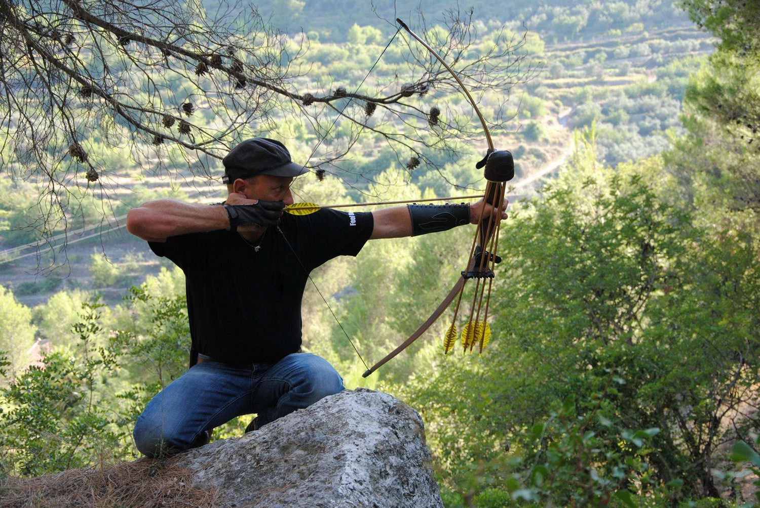 Sportbogen gespannt von Schütze auf Felsen